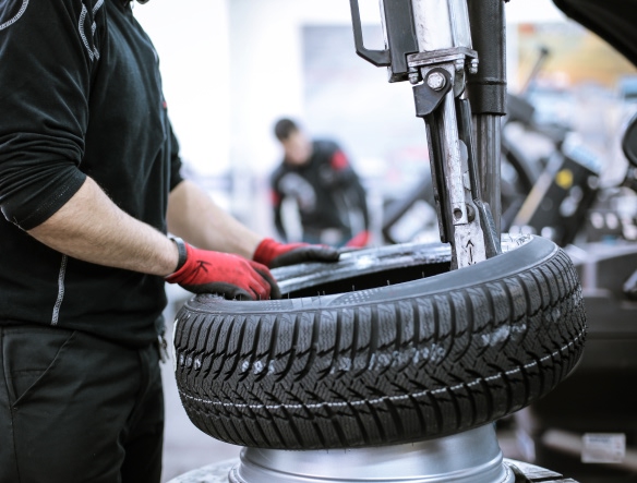 mechanic replacing tyre on machine