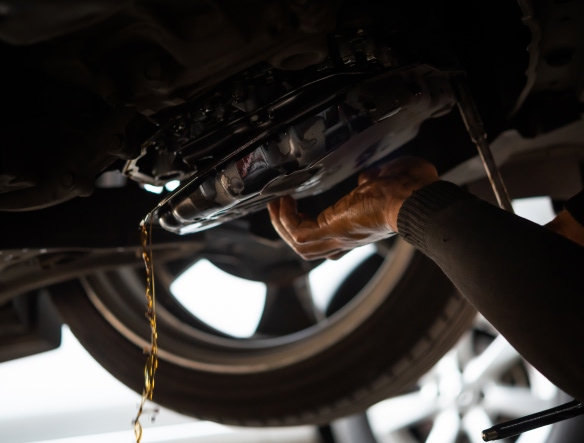mechanic removing oil pan to release oil